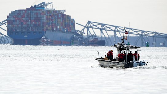 A US Coast Guard boat heads toward the collapsed Francis Scott Key Bridge wreckage.