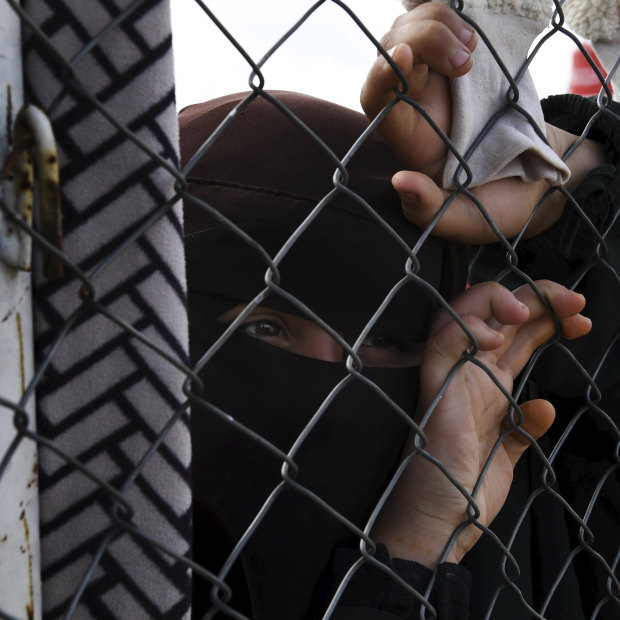 An Islamic State woman at the fence line of the foreign section of al-Hawl camp in Syria.