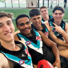 Port Adelaide footballer Tom Cochrane (centre) is congratulated by teammates (L-R) Jack Whitlock, Benny Barrett, Joe Berry and Christian Moraes after the club named him to make his debut.