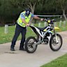 Police examine an electric off-road motorbike involved in a fatal crash in Edgewater on Saturday.