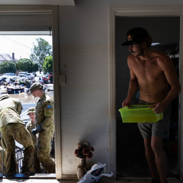 Members of the ADF join up with community volunteers to clear the house of an elderly couple.