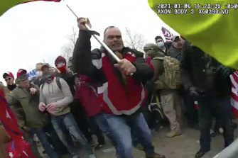 This still from a police body camera video shows Thomas Webster, in red jacket, at a barricade line at on the west front of the US Capitol on January 6, 2021.