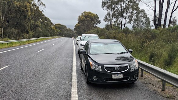 Cars stranded on the side of the Hume Freeway after hitting huge potholes.
