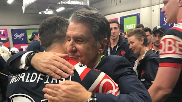 Gratitude: Nick Politis and Cooper Cronk embrace in the dressing room after the grand final victory.