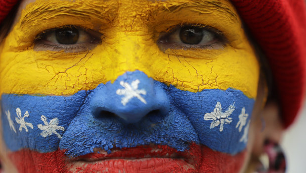 Her face painted in the colours of the national flag, a supporter of opposition leader Juan Guaido, Venezuela's self-proclaimed interim president, waits for his arrival in Los Teques on the weekend.
