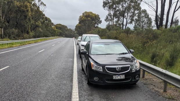 Cars stranded on the side of the Hume Freeway after hitting huge potholes.