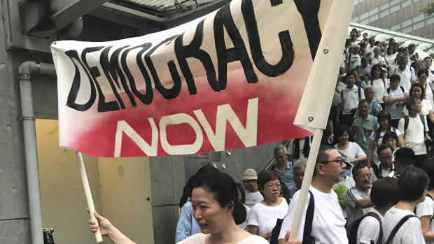 A woman holds a banner to demand full democracy in Hong Kong.