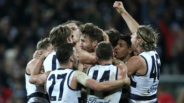 The Cats get around Zach Tuohy after his match-winning goal against Melbourne.