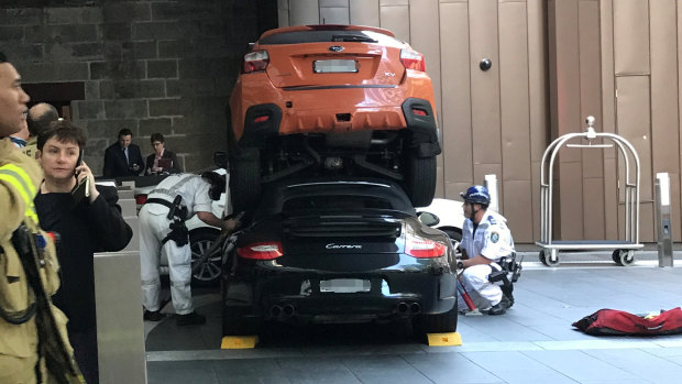 A Subaru mounted on top of a Porsche outside the Hyatt Regency Sydney hotel on Sussex Street on Thursday morning.