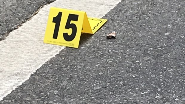 What appears to be the remnant of a bullet lies near a police marker on Mary Street.