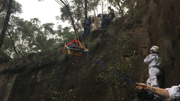 Delicate process: The man is rescued after falling down a cliff in the Blue Mountains.
