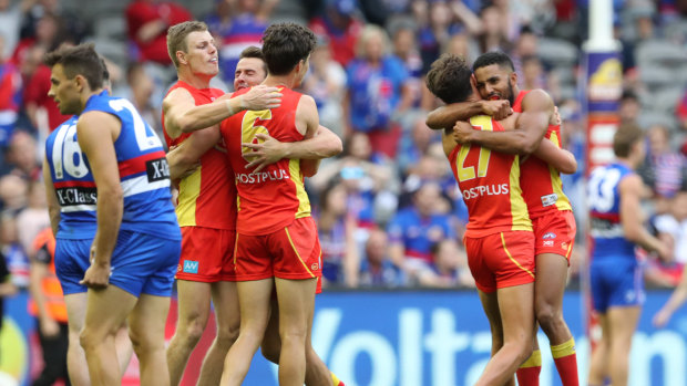Golden moment: The Suns celebrate their win over the Bulldogs at Marvel Stadium in Melbourne.