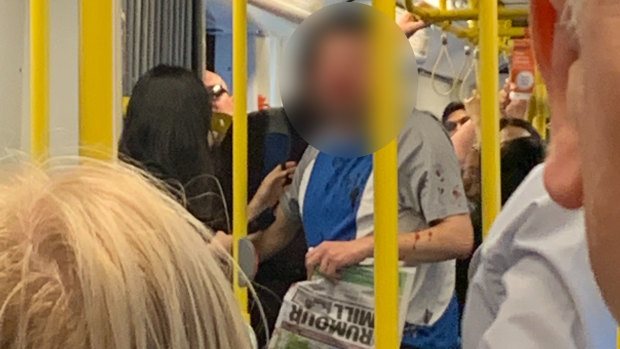 The victim with blood spattered on his shirt after a vicious assault on the 96 tram on Bourke Street. 