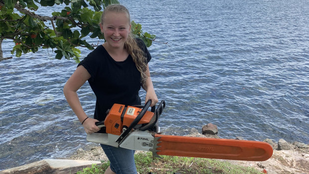 Jordanna Muddle with the result of her donation - a chainsaw, crucial during the school building's construction.