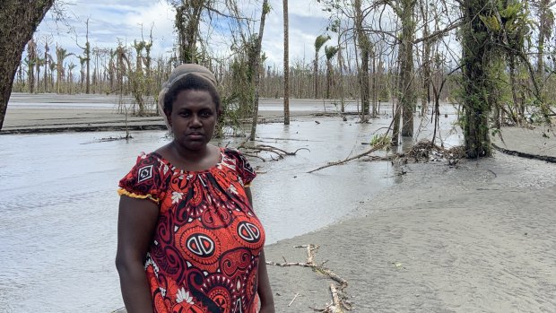 Theonila Roka Matbob in front of an area destroyed by mine waste flooding.