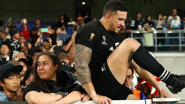Over the top: Sonny Bill Williams climbs the fence to join the crowd after the Rugby World Cup semi-final loss to England.