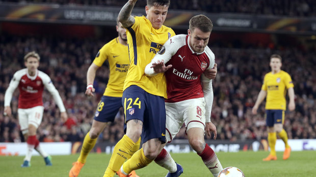 Tussle: Atletico's José Giménez and Arsenal's Aaron Ramsey battle for possession.