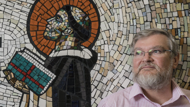 Australian Catholic University campus dean, Associate Professor Patrick McArdle, with the mural in the listed building.