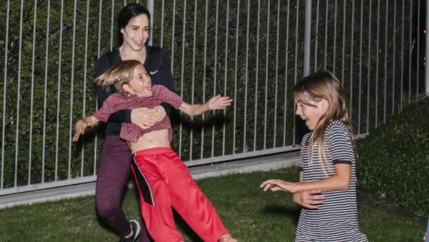Natalie Suleman plays with her children in the yard at home.