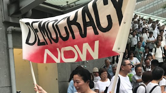 A woman holds a banner to demand full democracy in Hong Kong.