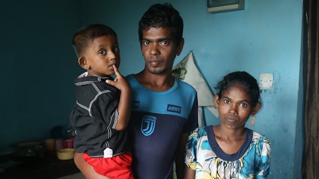 Sandun Rohitha with his wife Niluka and son Yenura. Without gas for
the past eight months, they
have been using firewood
and plastic sheets to cook.
