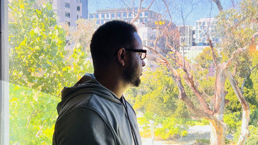 Ismail Hussein, 30, a refugee from Somalia looks out from his room at the Park Hotel in Melbourne.