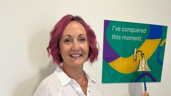Rachael Brooks-Donald with the bell that is traditionally rung to signal the end of breast cancer treatment.