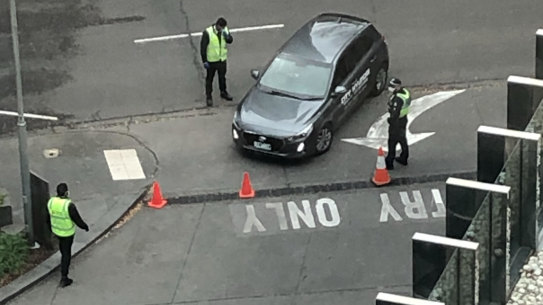 Guards and police at the entry of Crown Promenade last week. The hotel is one of 15 quarantine hotels in central Melbourne where returned travellers must spend 14 days in isolation.