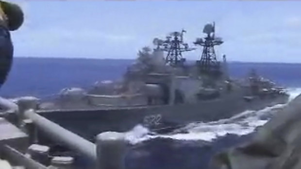 In this image from video provided the Russian destroyer, left, sails very close to the USS Chancellorsville.