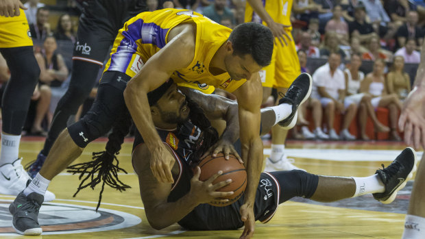 On the loose: Kevin Lisch of the Kings scraps for the ball with Jordair Jett of the Hawks.