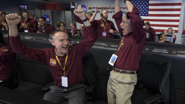 Mars InSight team members Kris Bruvold and Sandy Krasner rejoice inside the Mission Support Area at NASA's Jet Propulsion Laboratory in California after receiving confirmation that the Mars InSight lander had successfully touched down.