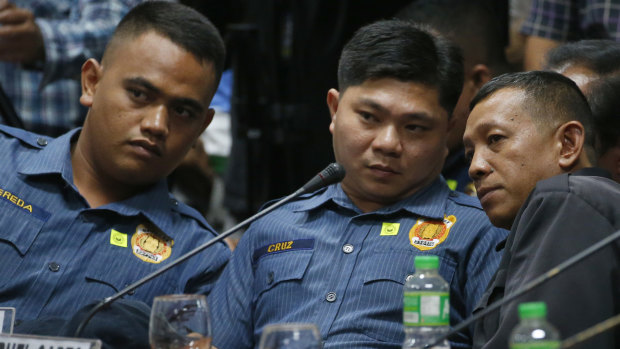 Philippine police officers Jeremias Pereda, Jerwin Cruz and Arnel Oares talk during a senate hearing on the killing last year.