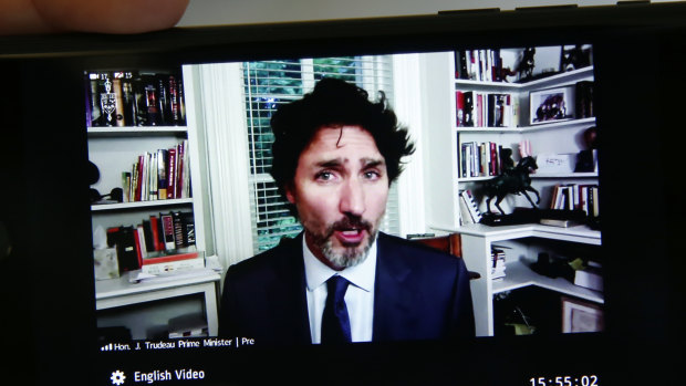 Canadian Prime Minister Justin Trudeau is seen on a mobile device speaking by video conference before the House of Commons standing committee in Ottawa, Ontario.
