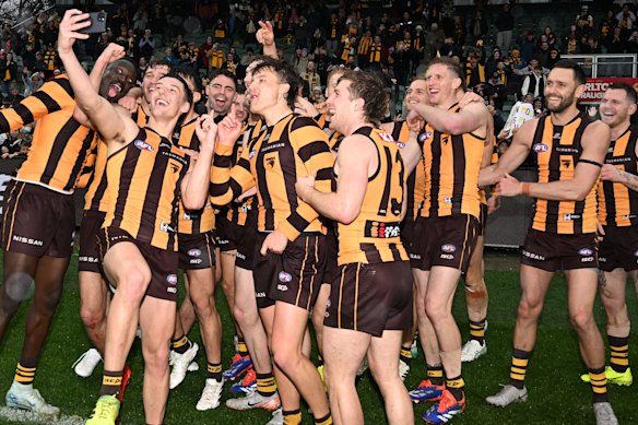 Hawks players celebrate by taking selfies in Launceston.