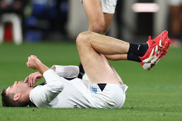 Mitch McGovern of the Blues hits the turf after taking a bump.