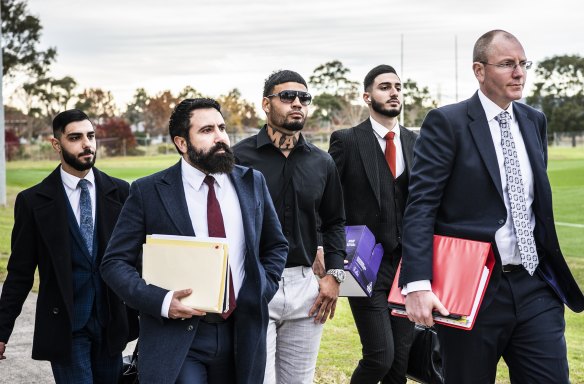 Taylan May (centre) walks into the board meeting flanked by his legal team earlier this month.