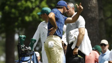 Battle: Jason Day holds his back on the fourth tee at Augusta.