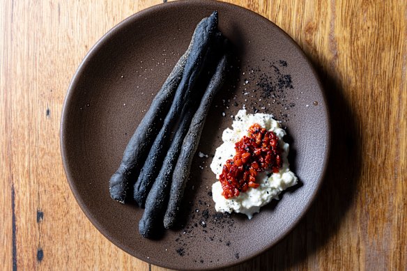 Leek ash grissini with fermented red peppers and stracciatella.