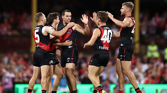 SYDNEY, AUSTRALIA - APRIL 08: Alec Waterman of the Bombers celebrates kicking a goal with team mates during the round four AFL match between the Sydney Swans and the Essendon Bombers at Sydney Cricket Ground on April 08, 2021 in Sydney, Australia. (Photo by Cameron Spencer/Getty Images)