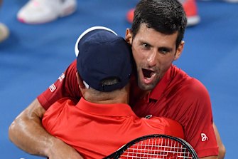 Djokovic hugs his doubles partner Viktor Troicki after defeating Edouard Roger-Vasselin and Nicolas Mahut.