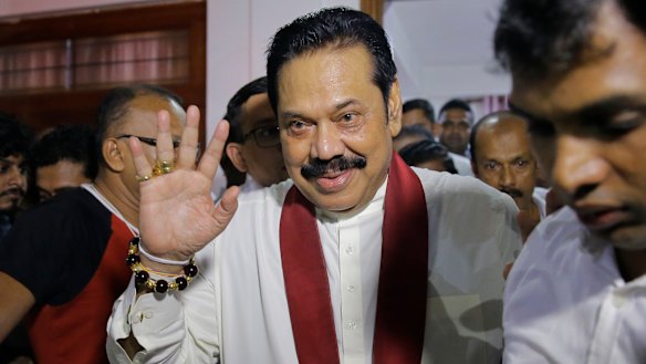 Newly appointed Sri Lankan Prime Minister Mahinda Rajapaksa, center, leaves a Buddhist temple after meeting his supporters in Colombo.