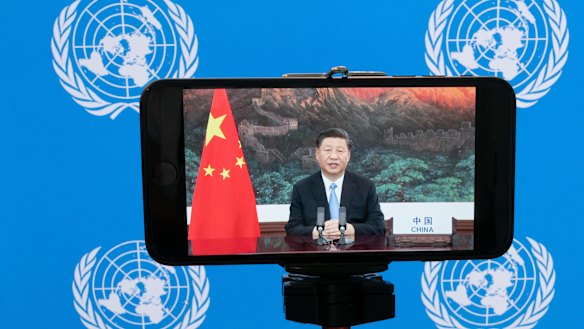 Chinese President Xi Jinping is seen on a phone screen remotely addressing the 75th session of the United Nations General Assembly.