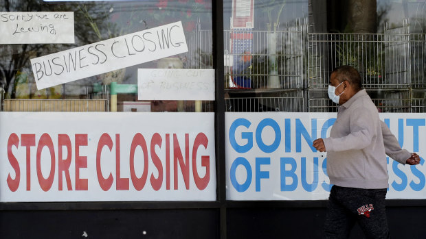 A man looks at signs of a closed store due to COVID-19 in Niles, Illinois. 