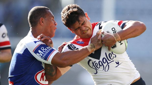 Latrell Mitchell fends off Will Hopoate in the Roosters win over the Bulldogs on Sunday. 