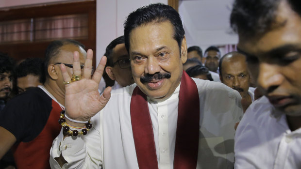 Newly appointed Sri Lankan Prime Minister Mahinda Rajapaksa, center, leaves a Buddhist temple after meeting his supporters in Colombo.