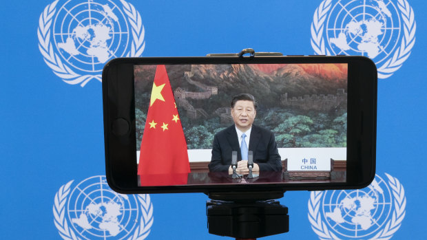 Chinese President Xi Jinping is seen on a phone screen remotely addressing the 75th session of the United Nations General Assembly.