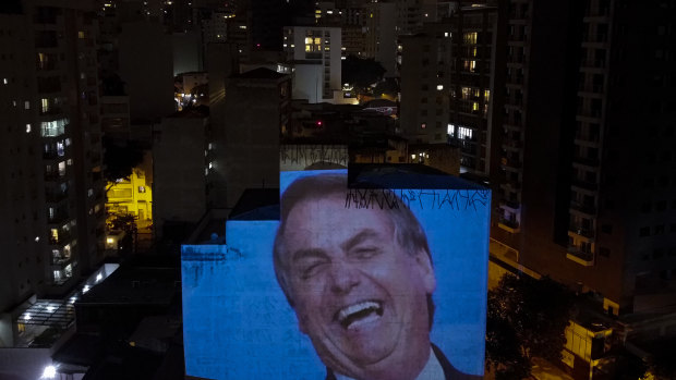 An image of Jair Bolsonaro is projected on a building's wall as residents bang pots and pans in Sao Paulo on Thursday evening.
