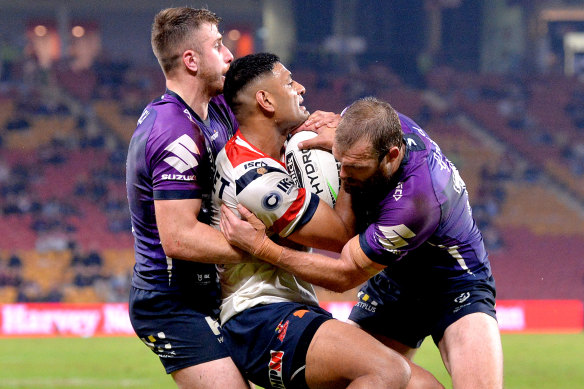 Daniel Tupou of the Roosters comes under some heavy pressure from the Storm.
