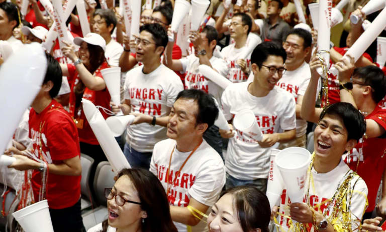 Employees of Nissin Food Products watch the live broadcast of the US Open final.