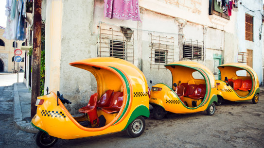 Yellow coco-taxis parked at a street of Havana.